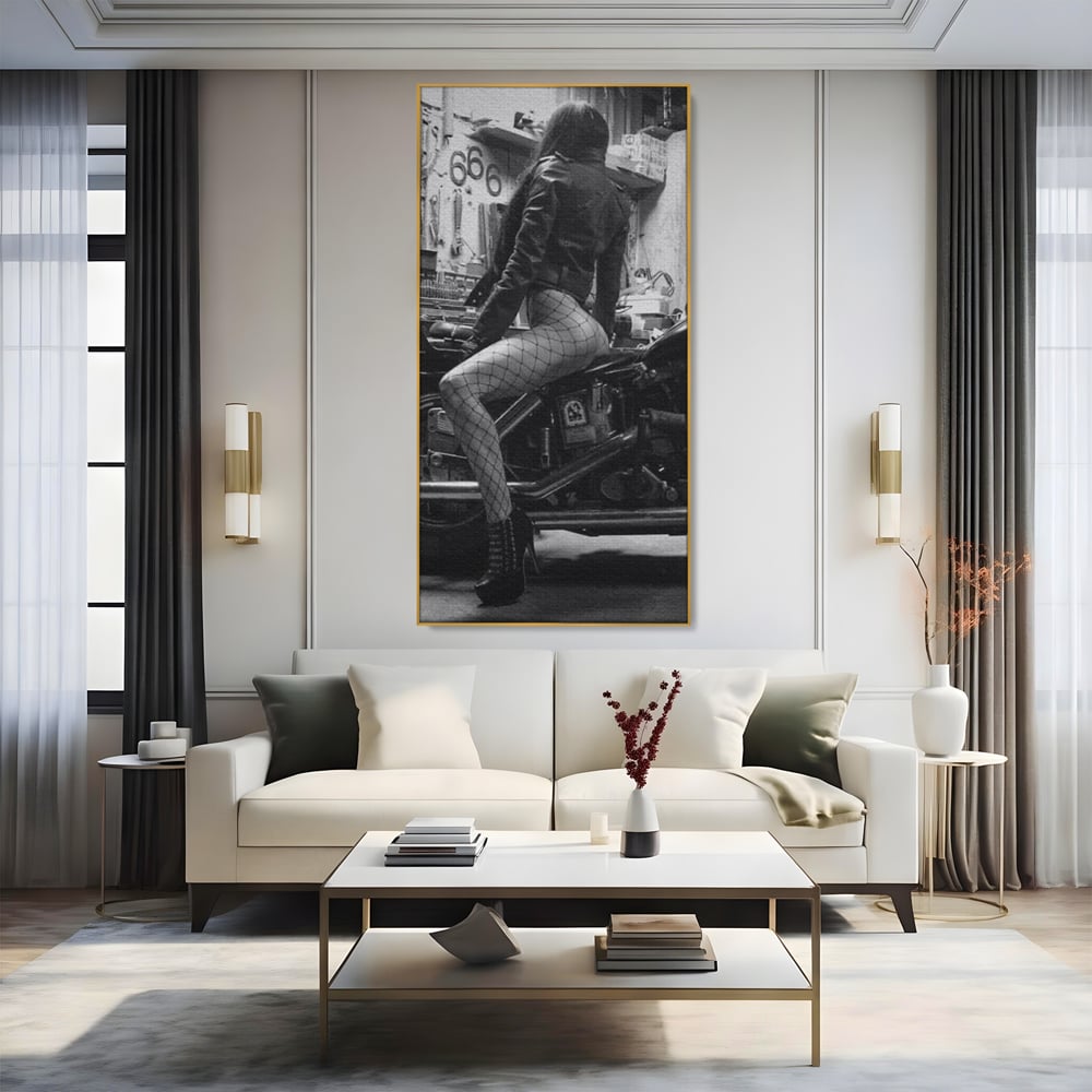 Tablou canvas cu tablou canvas cu femeie pe motocicleta, in rama de aluminiu auriu, pe perete intr-un living